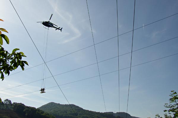 Fils du r�seau �lectrique et nacelle soutenue par un h�licopt�re.